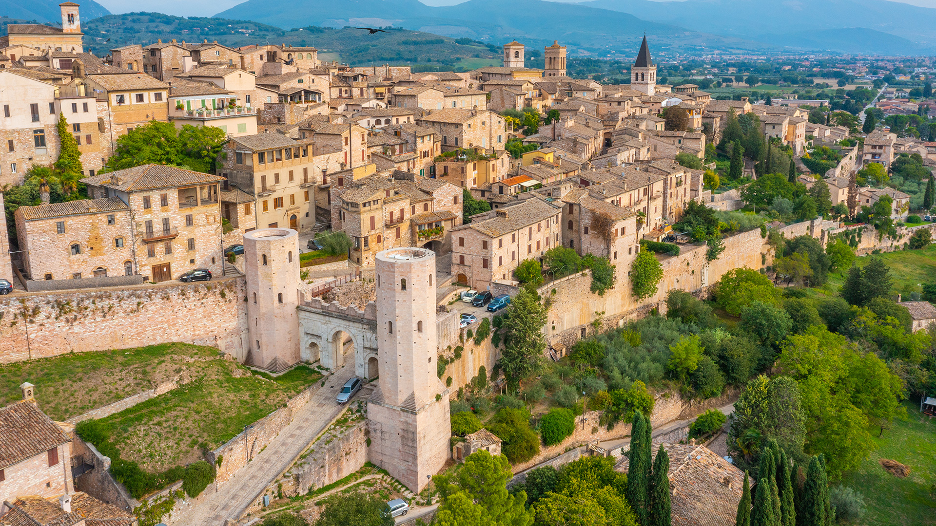 Aerial view of Viterbo’s medieval city walls, historic towers and terracotta rooftops, surrounded by the green hills of Tuscia, Italy.