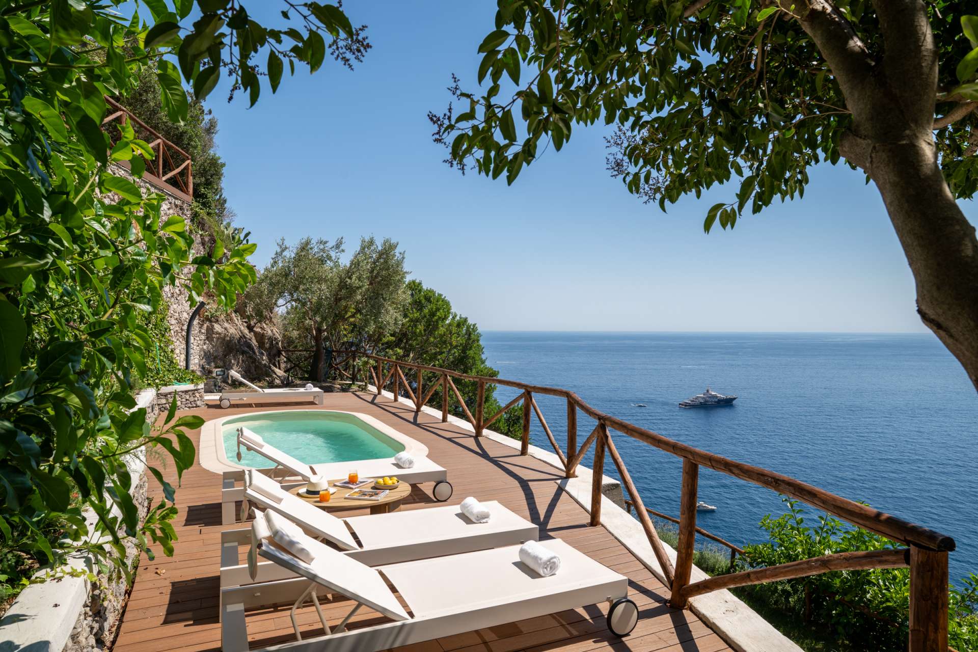 Private pool terrace at Limoni Sul Mare with sun loungers and panoramic views over the Mediterranean Sea near Maiori on the Amalfi Coast.