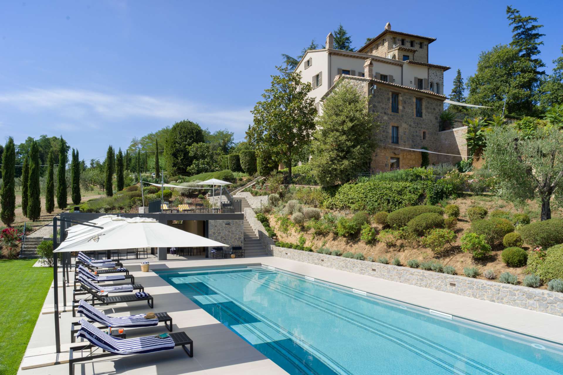 Panoramic view of Villa Clara, a luxury Tuscan villa with a private pool, surrounded by cypress trees and lush gardens