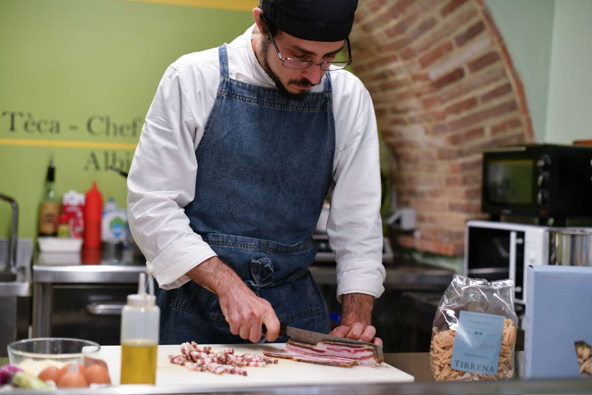 Private chef at Villa Albizi preparing fresh Tuscan ingredients in the kitchen