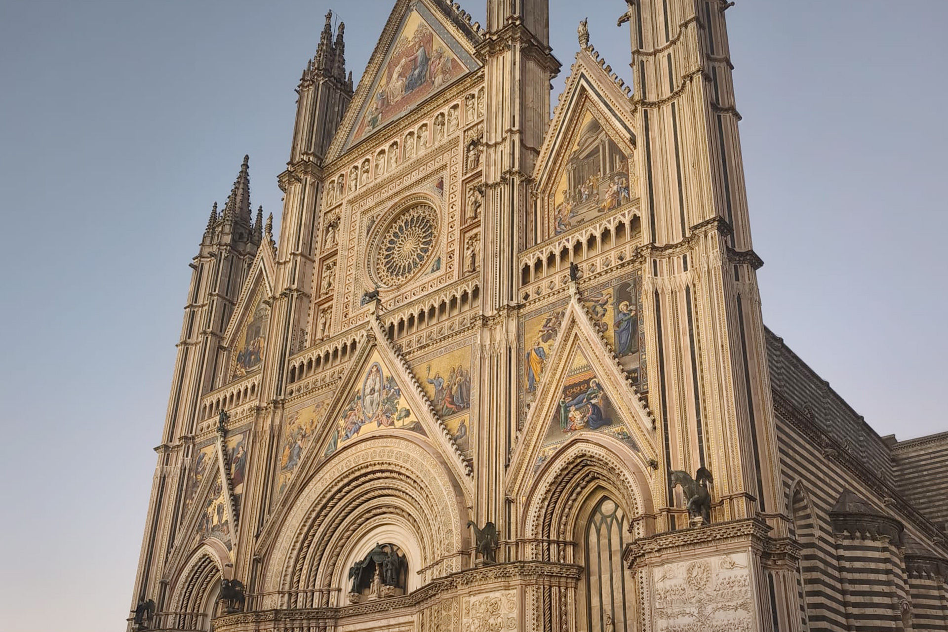 Orvieto Cathedral Umbria Italy Gothic facade with mosaics and rose window at sunset