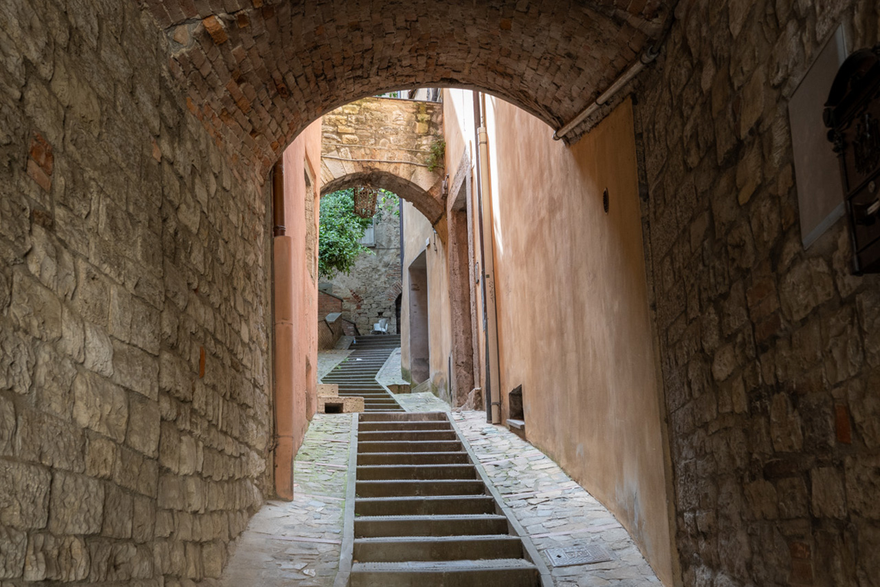 Medieval stone passageway in Todi, Umbria, Italy. Narrow stone alley with arches and steps in the historic center of Todi, Umbria, Italy.