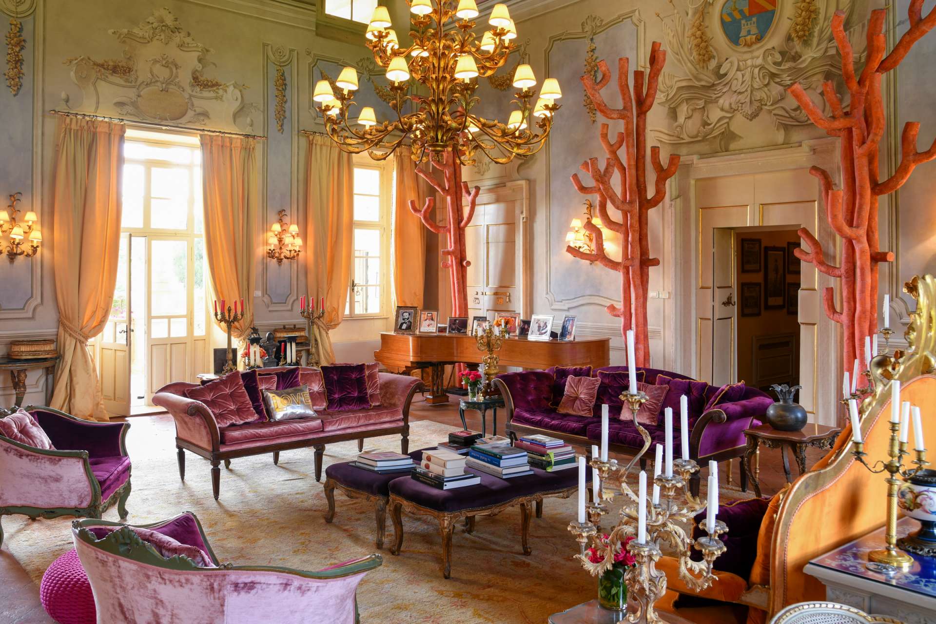 Luxury historic living room at Villa Sigurtà in Italy Luxury historic living room at Villa Sigurtà featuring chandeliers, ornate stucco details, velvet sofas, and elegant classical décor