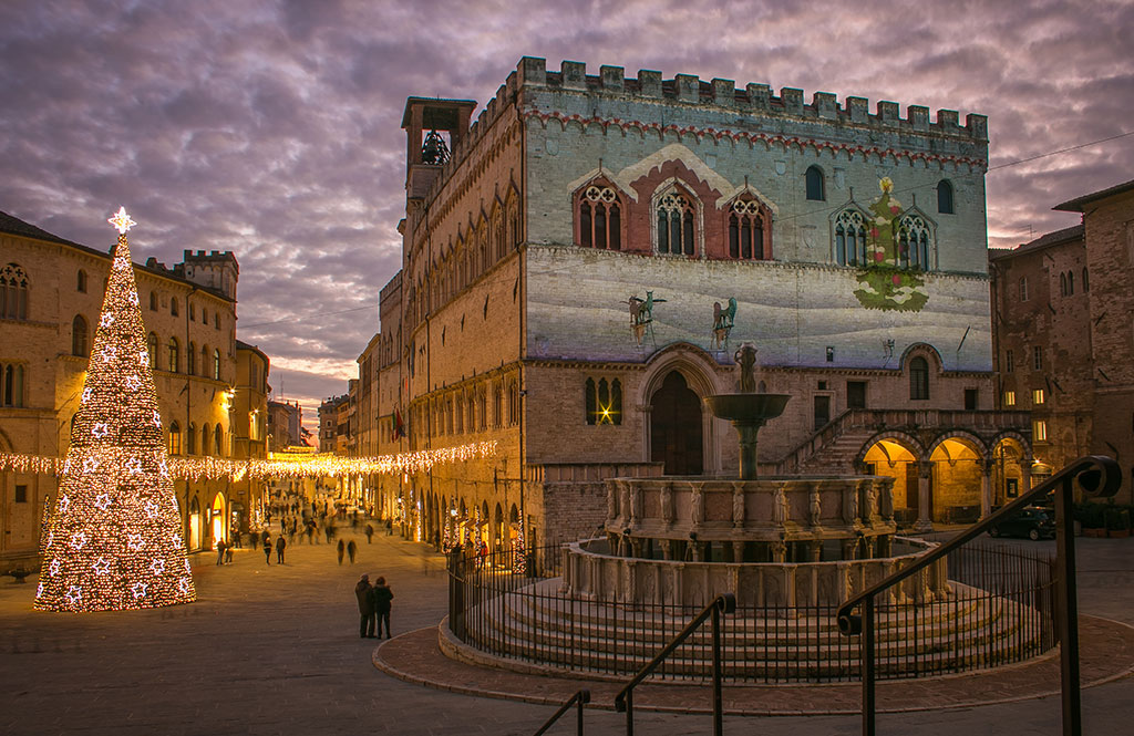 Beautiful view of the Piazza IV November with christmas tree in the medieval center of Perugia during dusk, Umbria, Italy