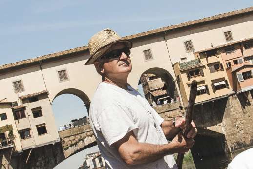 Arno Gondola Ride - A gondola driver moves the gondola past Ponte Vecchio, Florence’s oldest bridge.