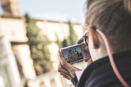 Arno Gondola Ride - A woman photographs the Basilica of Santa Maria Novella.
