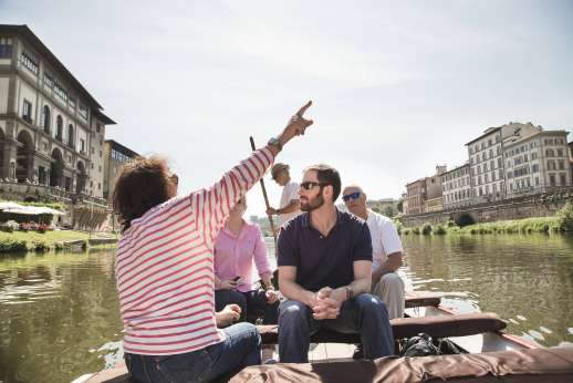 Arno Gondola Ride - A person points to a landmark during a gondola tour of the river Arno.