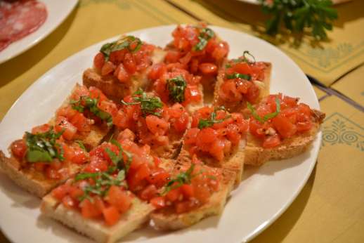 Fiat 500 Tour - Seasoned tomatoes on bread are laid out on a table.