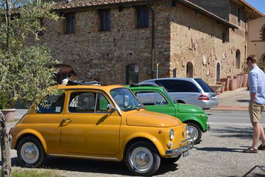 Fiat 500 Tour - Two classic Fiat 500s parked next to a traditional Tuscan villa.