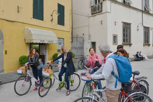 Lucca By Bike Or Foot - A tour group on bicycles stops to listen to their guide in the middle of Lucca