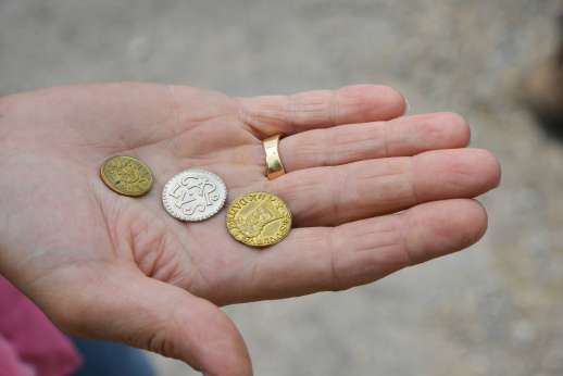 Lucca By Bike Or Foot - Antique coins in the palm of a hand.