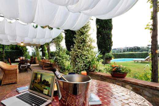 I Tre Cipressi - The large loggia looking towards the pool and hill top village in the distance.