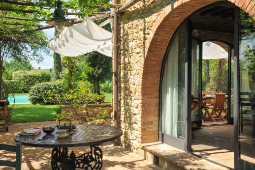 I Tre Cipressi - Seating under the pergola leading into the kitchen