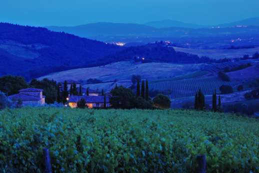 I Tre Cipressi - The view by night over the tuscan vineyards and hilltop villages.