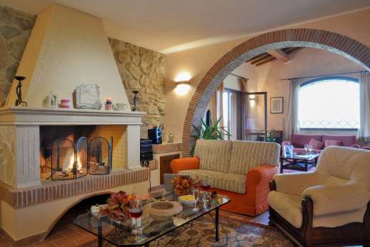 Il Chiesino - Ground floor sitting room with an open fireplace and French doors leading out to the two loggias.