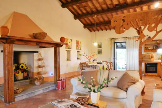 La Grande Quercia - Open plan living area with a dining table and a fireplace.