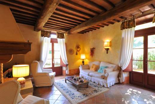 Podere Celli - Open plan sitting room with open fireplace with doors leading outside