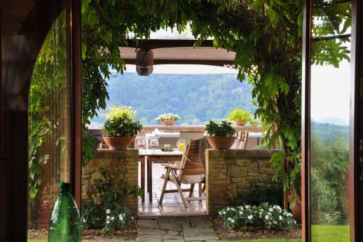 Podere Celli - View for the villa towards another shaded eating area