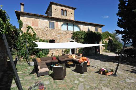 Tizzano - Large paved courtyard with shaded seating area.