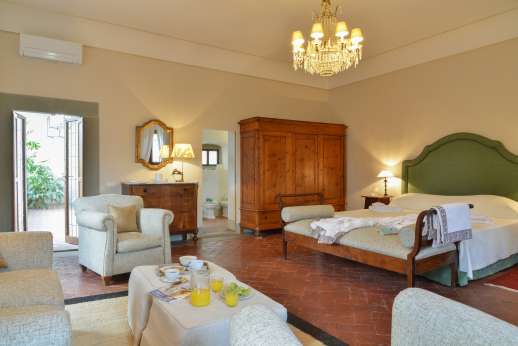 Weddings at Villa Di Masseto - Double bedroom with sofas and antique furniture.