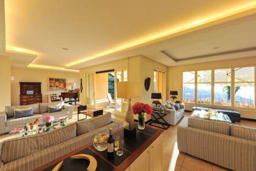 Bellaria - Large living room with sofa, fireplace, piano and TV.