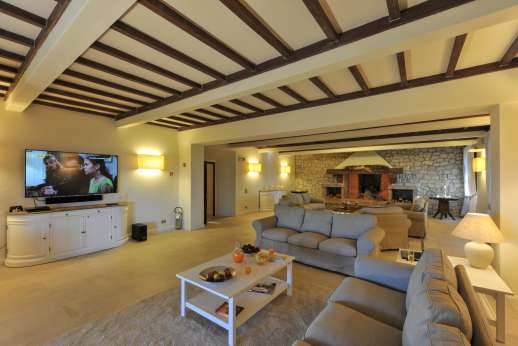 Villa Ostignano - Ground floor air conditioned living room with large smart TV and working fireplace.