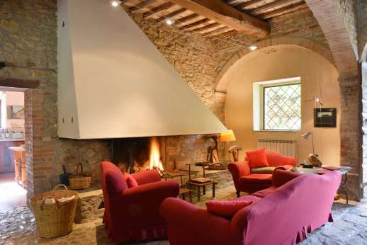 La Pergola di Montegiove - Large living room with a fireplace leading out to the garden.