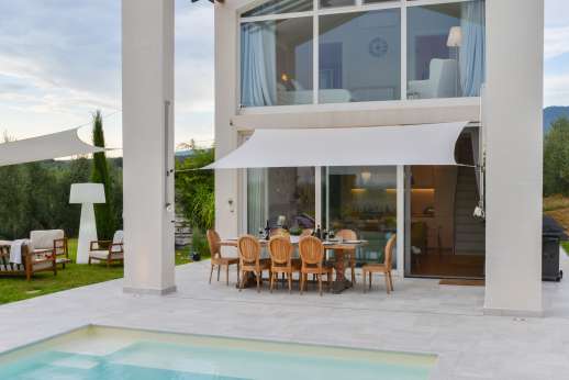 Villa Amerini - Two shaded seating areas, one with a dining table, the second with a sophisticated and comfortable seating area.