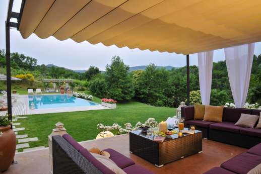 Podere Brogi - Shaded outdoor seating area by the pool