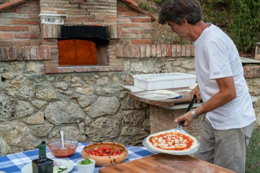 Palazzo Cheto - Cook making pizza in the outdoor pizza oven