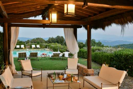 Belsguardo - Shaded seating area by the pool lit in the evening