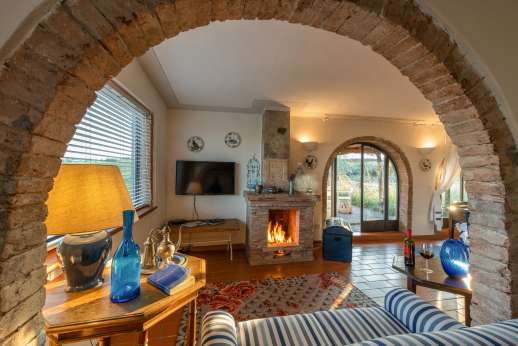 Palazzo Nelle - The loft main living area with fireplace leading out to the pool