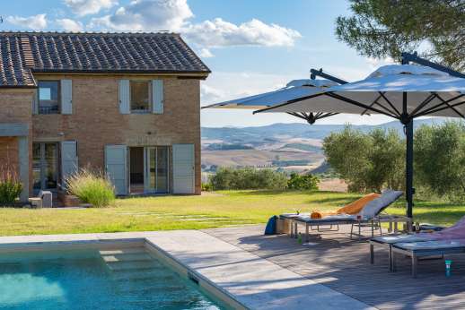 PodereSole - A lush garden dotted with olive groves and cypress trees surrounds the fenced property
