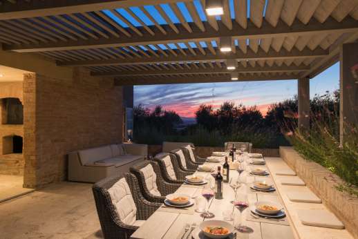 PodereSole - Covered loggia boasts a large dining table and modern aperitif area, served by a barbecue and wood-burning oven