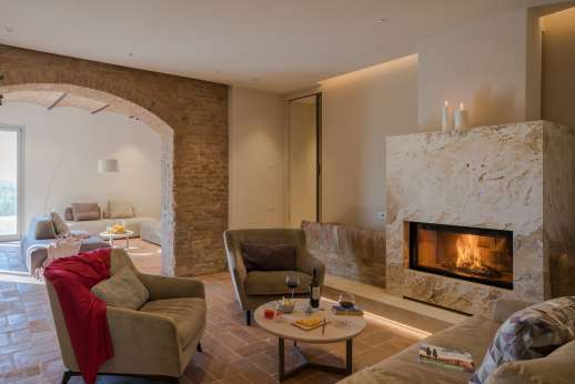 PodereSole - The living area of this space is elegantly furnished with a travertine fireplace