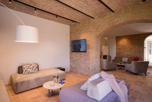 PodereSole - Broken-plan living area furnished with comfy sofas, pouffes, armchairs