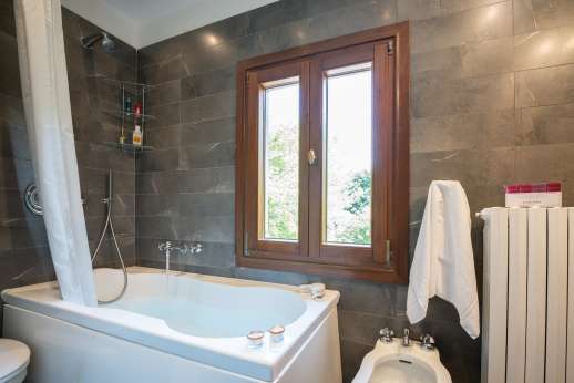 Villa Michiel - A bathroom with bath.