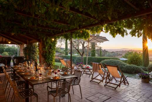 La Badiole - Dining loggia with view across the lawn and the rolling hills of Tuscany