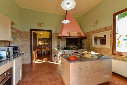 Villa Astori - The well-equipped kitchen with a fireplace.