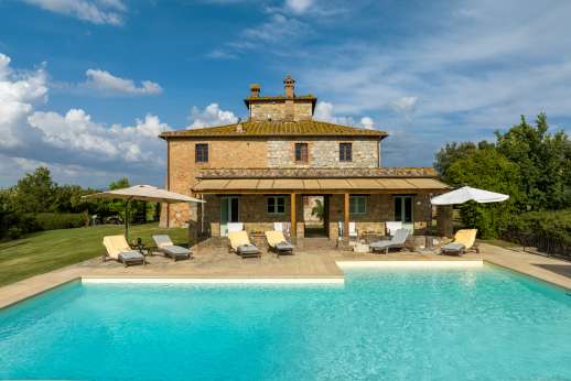 La Piana - View of the pool, pool house and villa, with the pergola set just to the side.