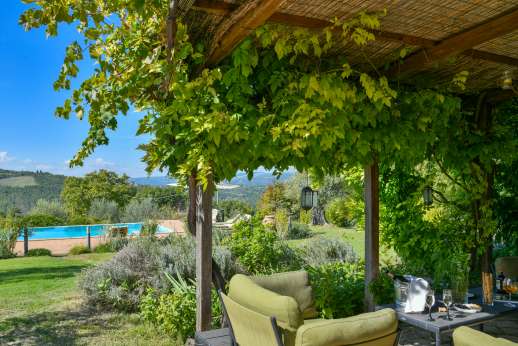 La Pianstella - A large loggia with garden furniture and a dining table facing the valley.