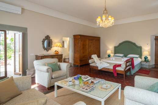 Villa Di Masseto - Double bedroom with sofas and antique furniture.