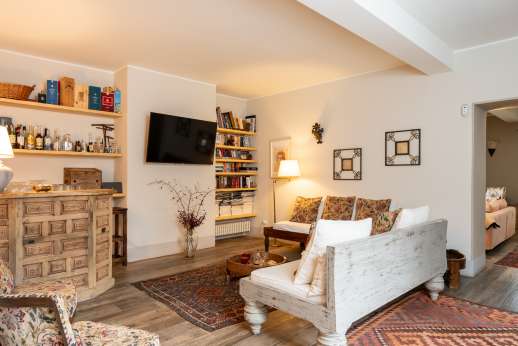 Loliondo - a second lounge area with TV, sofas, a bookcase and a corner dry bar